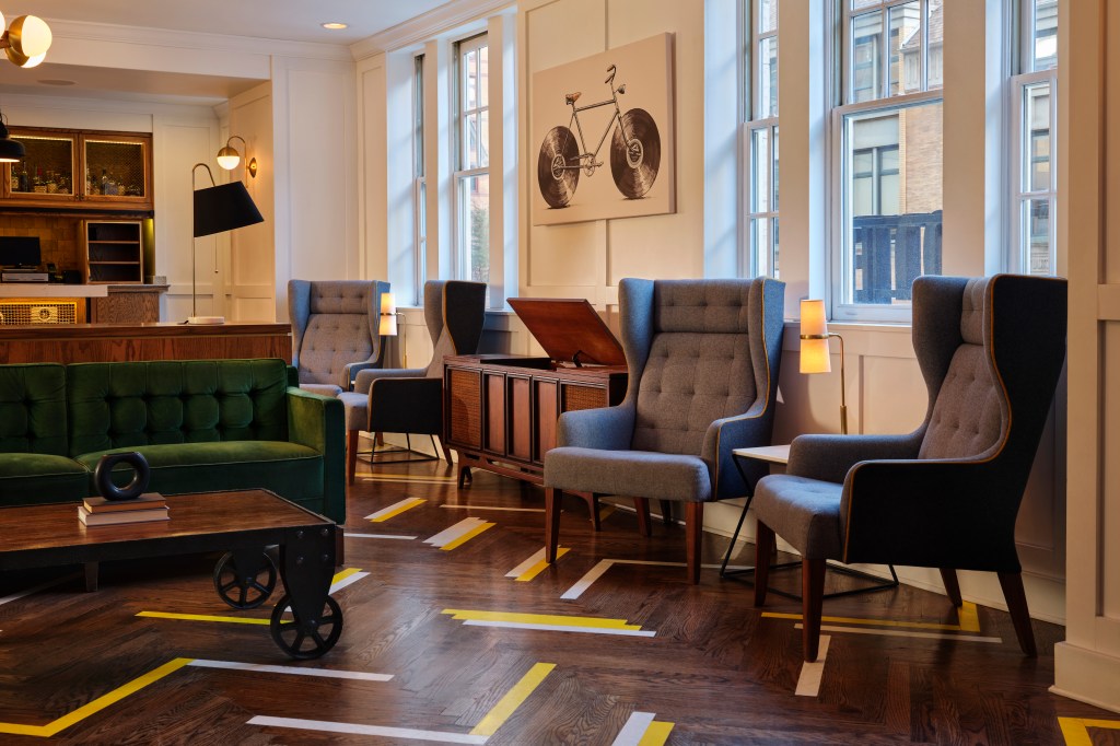 ACME Hotel Chicago - Lobby, lobby with a variety of seating, large bicycle artwork, wooden floor with colorful white and yellow stripes