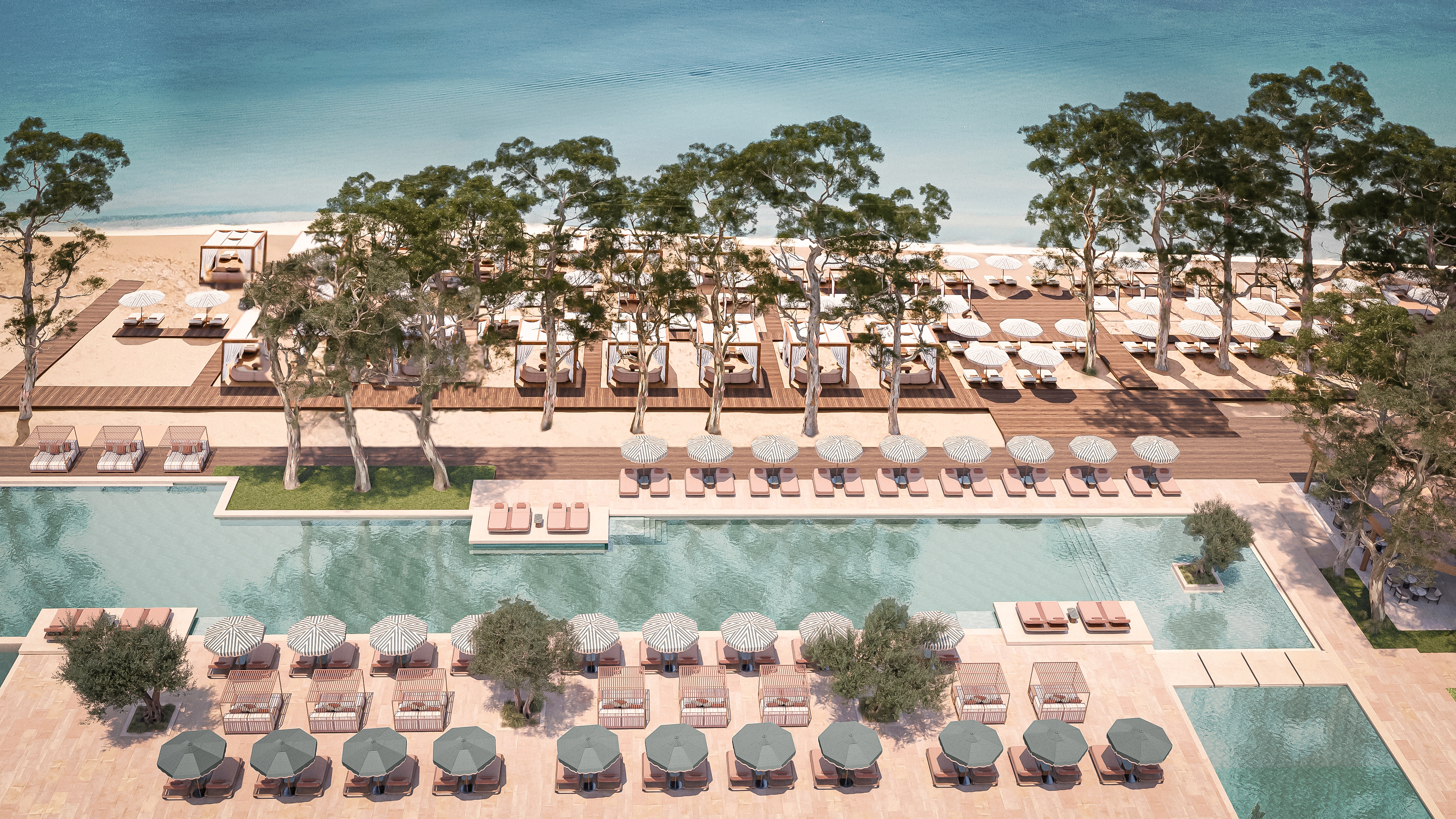 Conrad Corfu - Outdoor Pool - long pool surrounded by lounge chairs and cabanas, leading to beach area with trees, lounge chairs and cabanas