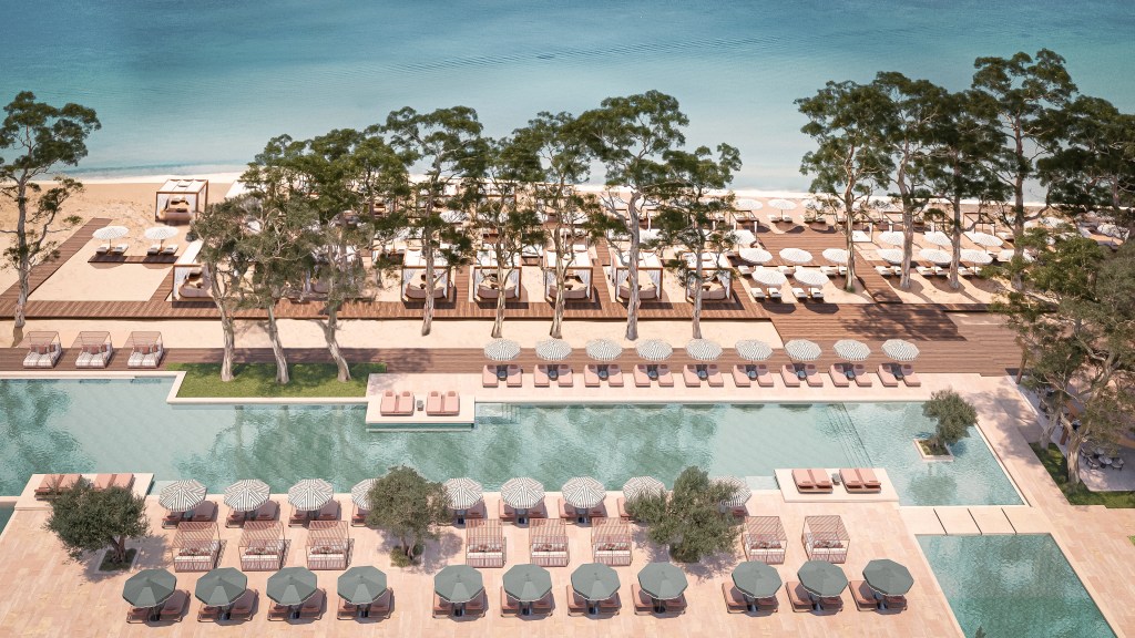 Conrad Corfu - Outdoor Pool - long pool surrounded by lounge chairs and cabanas, leading to beach area with trees, lounge chairs and cabanas