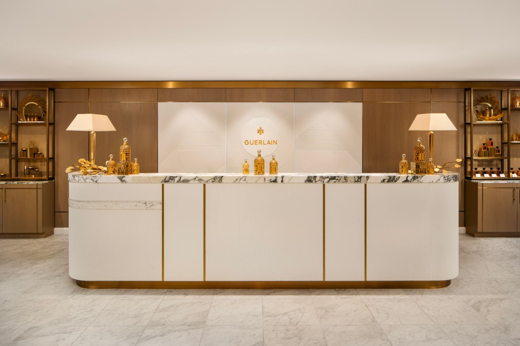 Guerlain Spa reception with marble and gold accents.