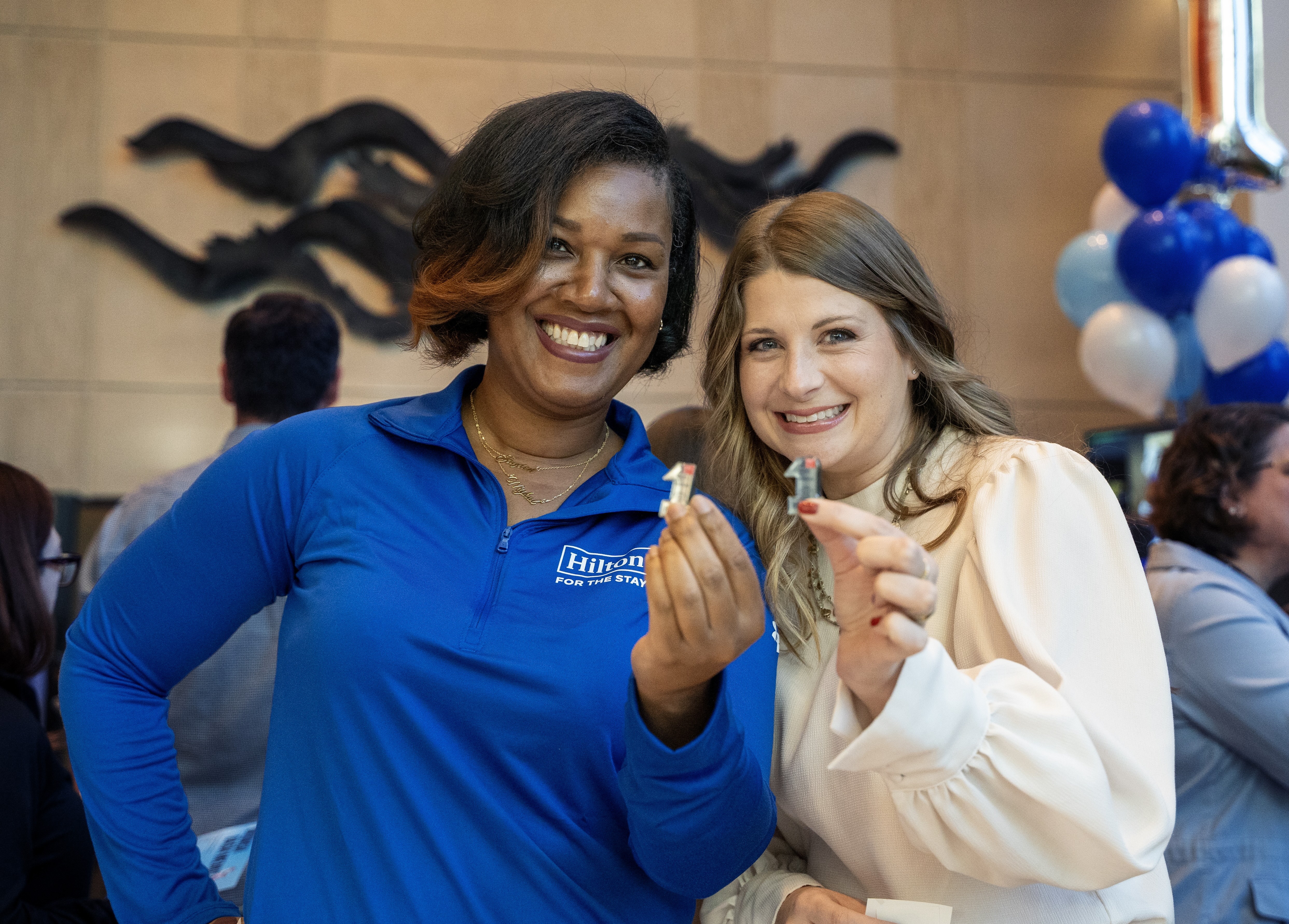 Two Hilton team members smiling during a celebration