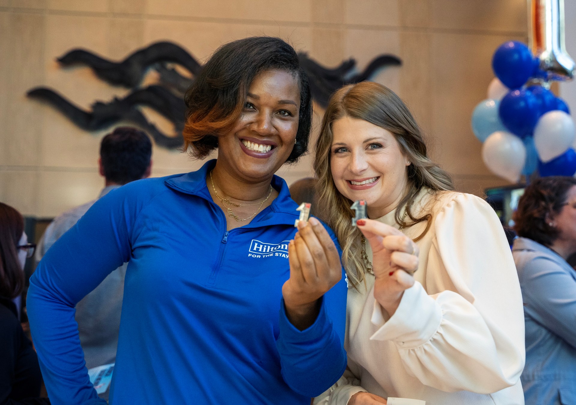 Two Hilton team members smiling during a celebration