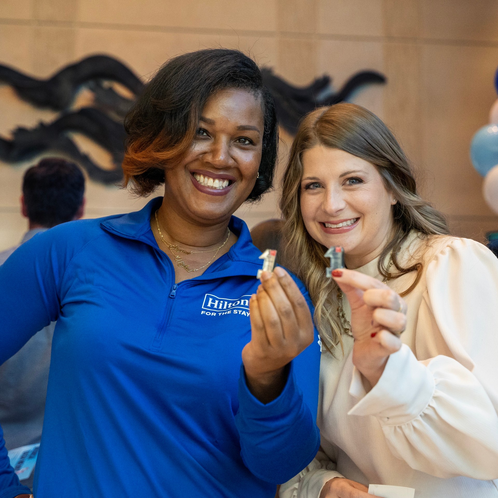 Two Hilton team members smiling during a celebration