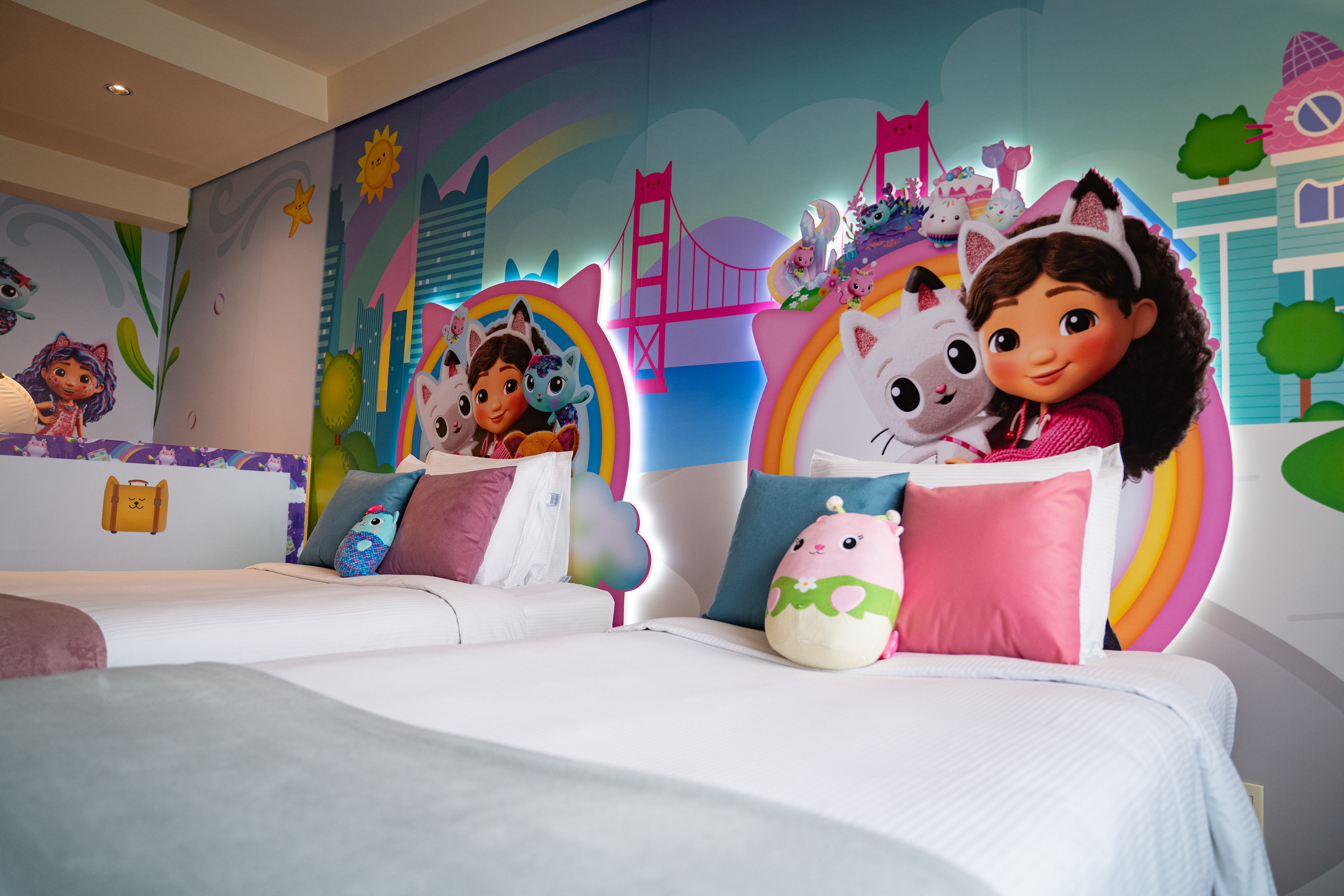 Two beds surrounded by imagery from DreamWorks Animation’s Gabby's Dollhouse The Movie