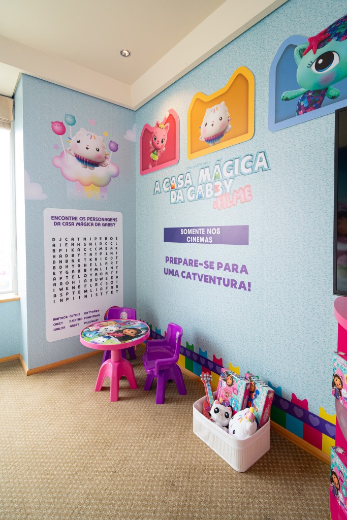 A corner of the room with a child sized table and chairs, basket of toys, surrounded by imagery from DreamWorks Animation’s Gabby's Dollhouse The Movie