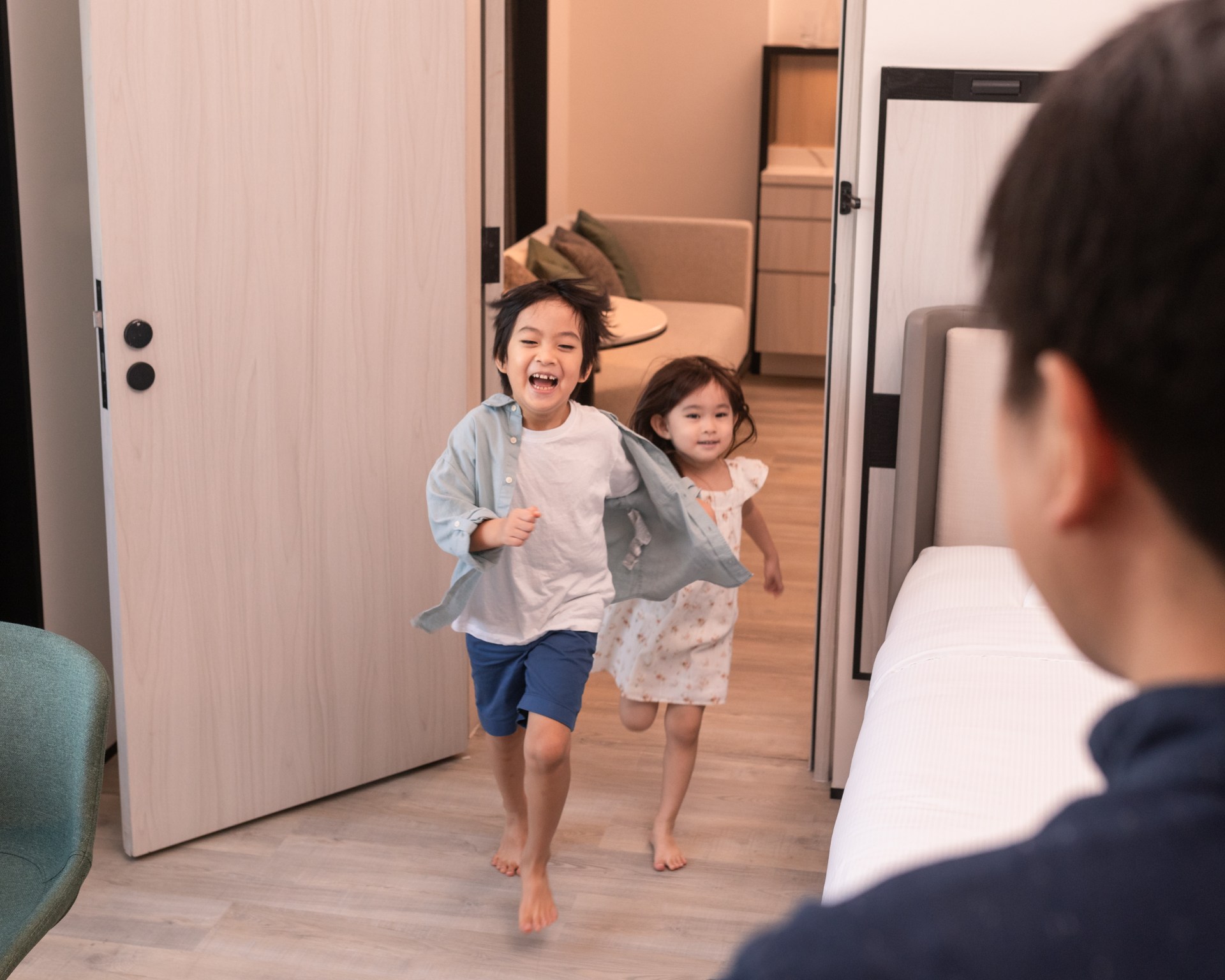 Hilton Singapore Orchard, happy children running toward parents in guest room