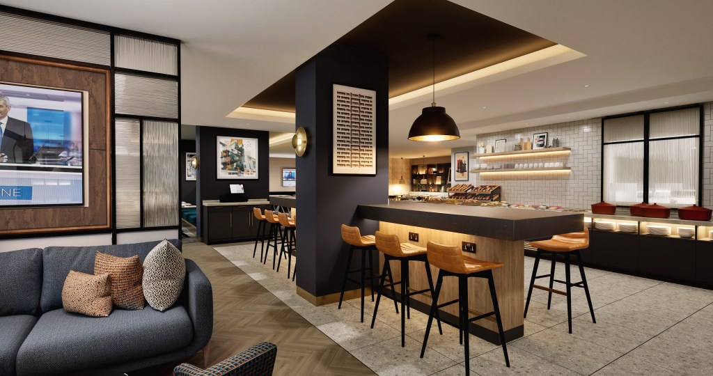 A common area with a buffet of food, bar height seating and couches.