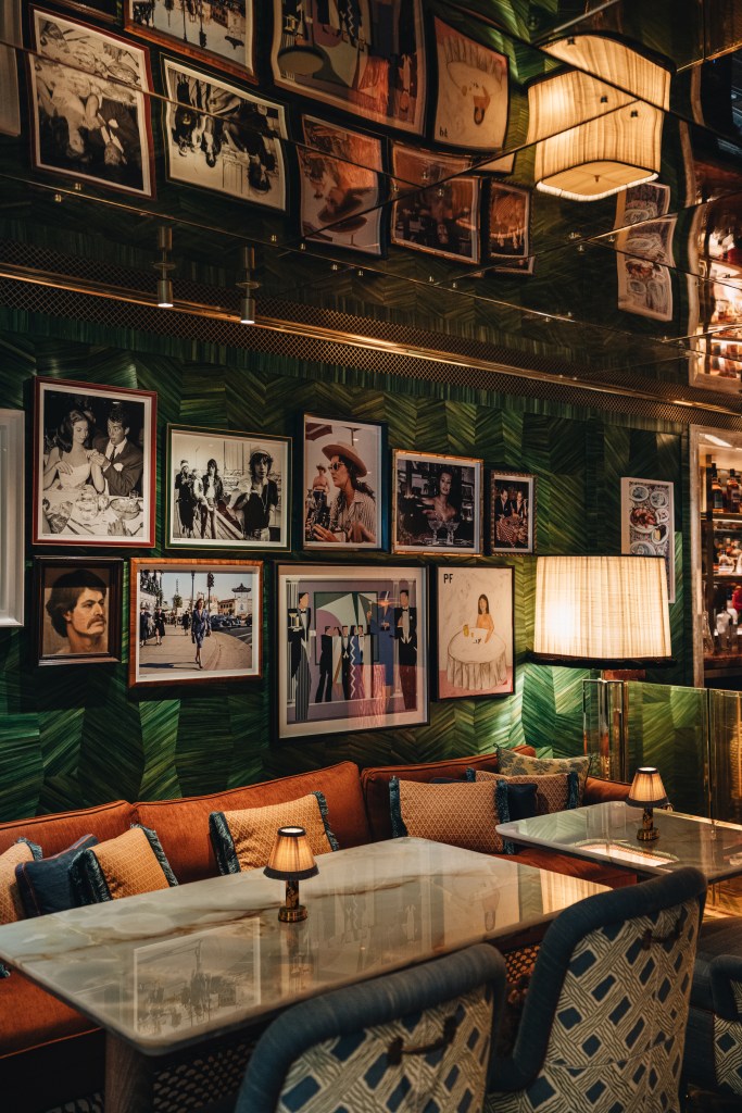 Tables at La Monique with bench seating a wall full of art.