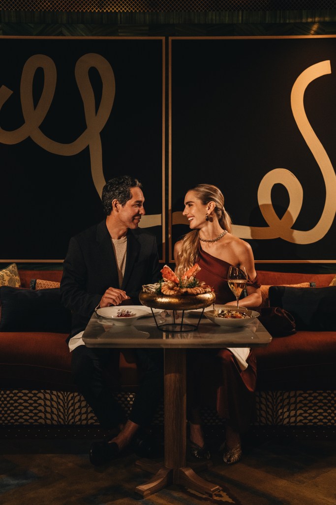 A couple eating dinner at a table, smiling at each other