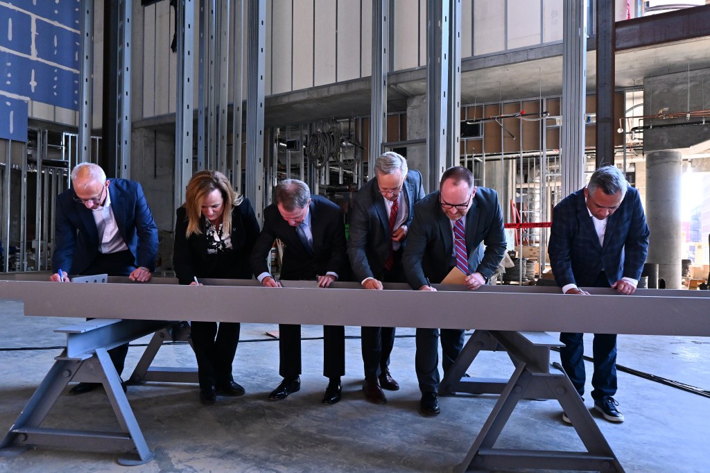 Signia by Hilton Indianapolis beam signing - From L-R: Gary Steffen, senior vice president and global category head, Hilton’s Full Service Brands; Kathy Heneghan, general manager, Signia by Hilton Indianapolis; Mayor Joe Hogsett, City of Indianapolis; Bill Sewall, vice president, AECOM; Andy Mallon, executive director, Capital Improvement Board and Leonard Hoops, president &amp; CEO, Visit Indy.