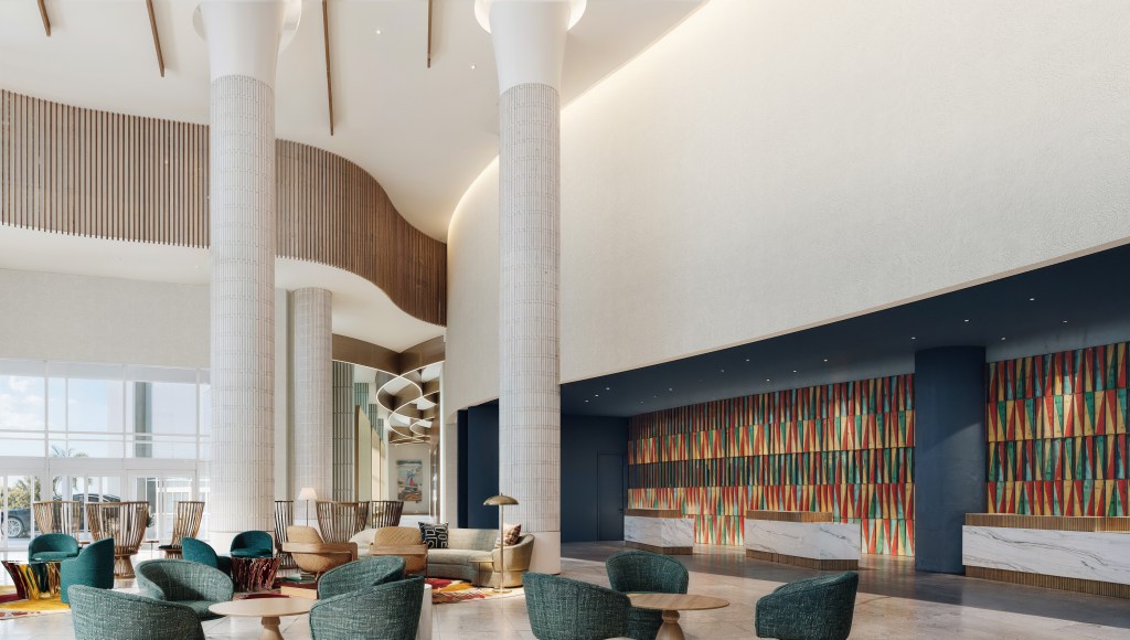 The lobby of the hotel with various seating options, and front desks back with colorful mosaics