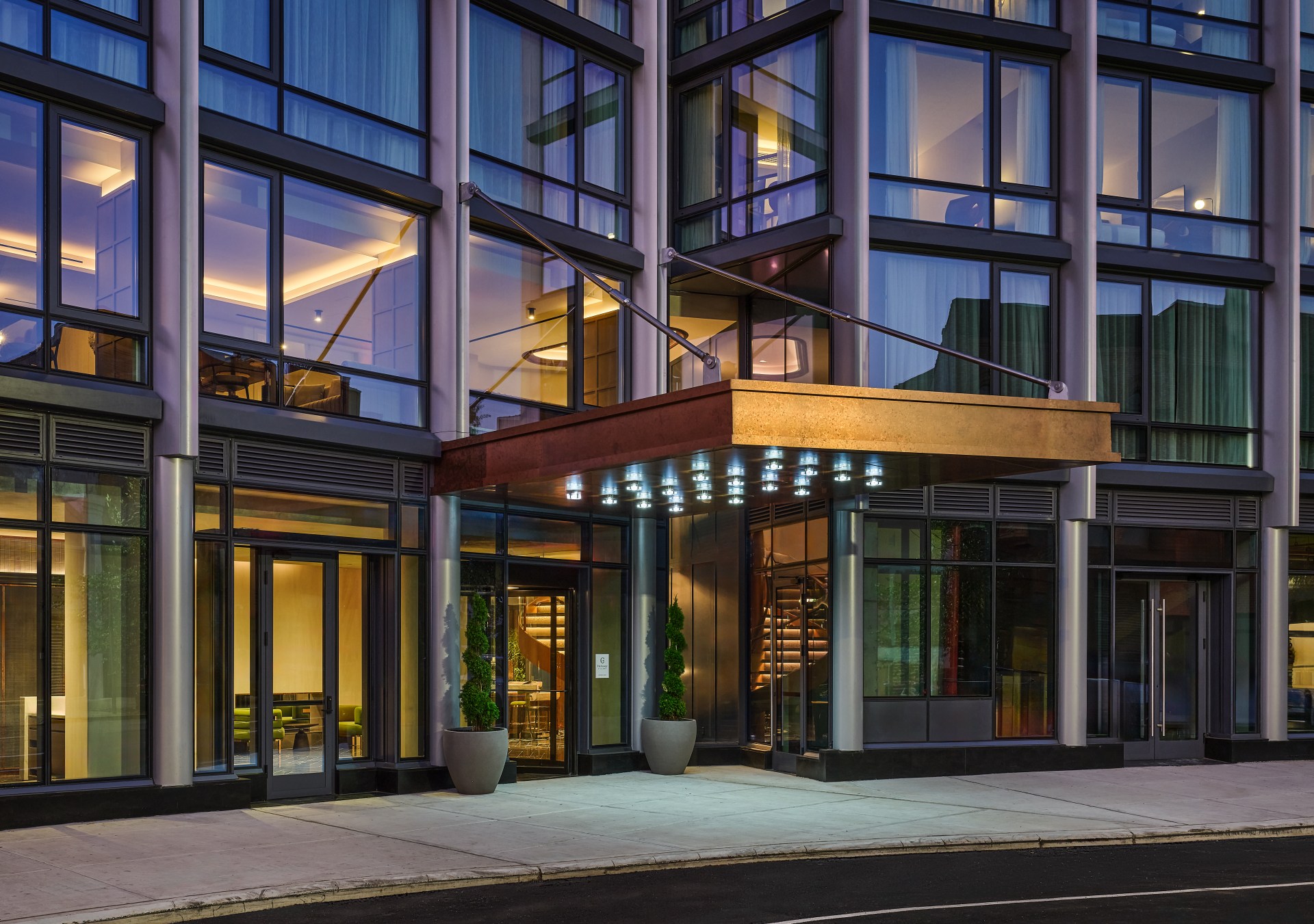 The entrance of the hotel surrounded by windows.