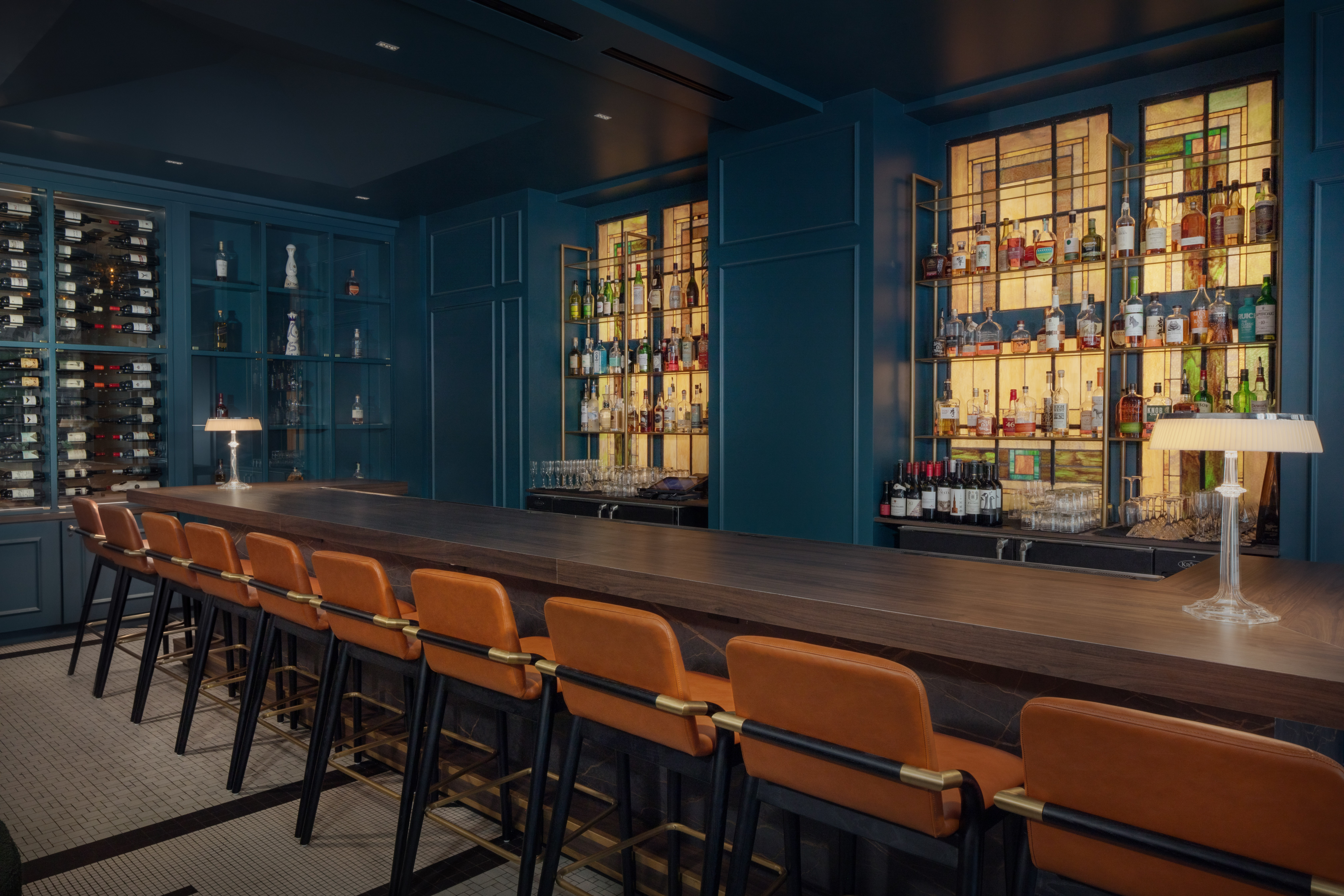 A backlit bar with wood and leather accents