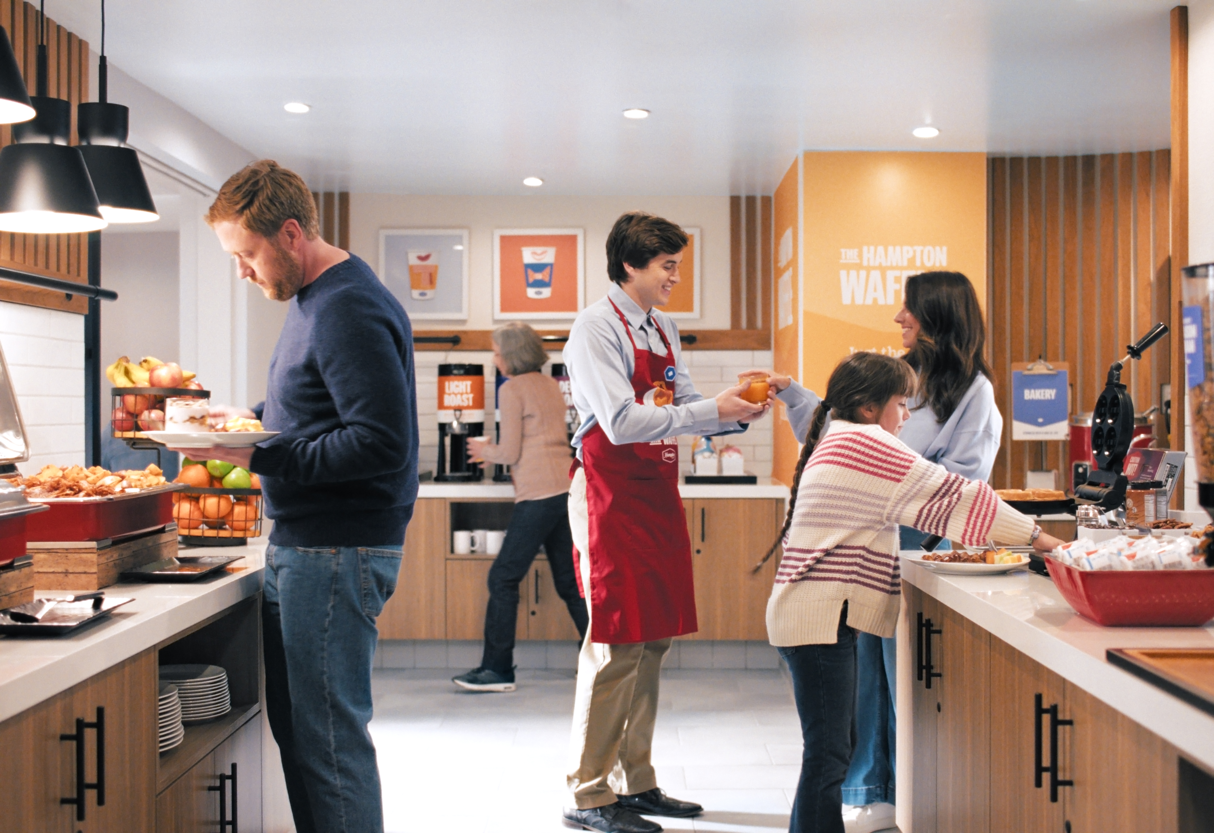 Guests and Hampton by Hilton Team members interacting at breakfast