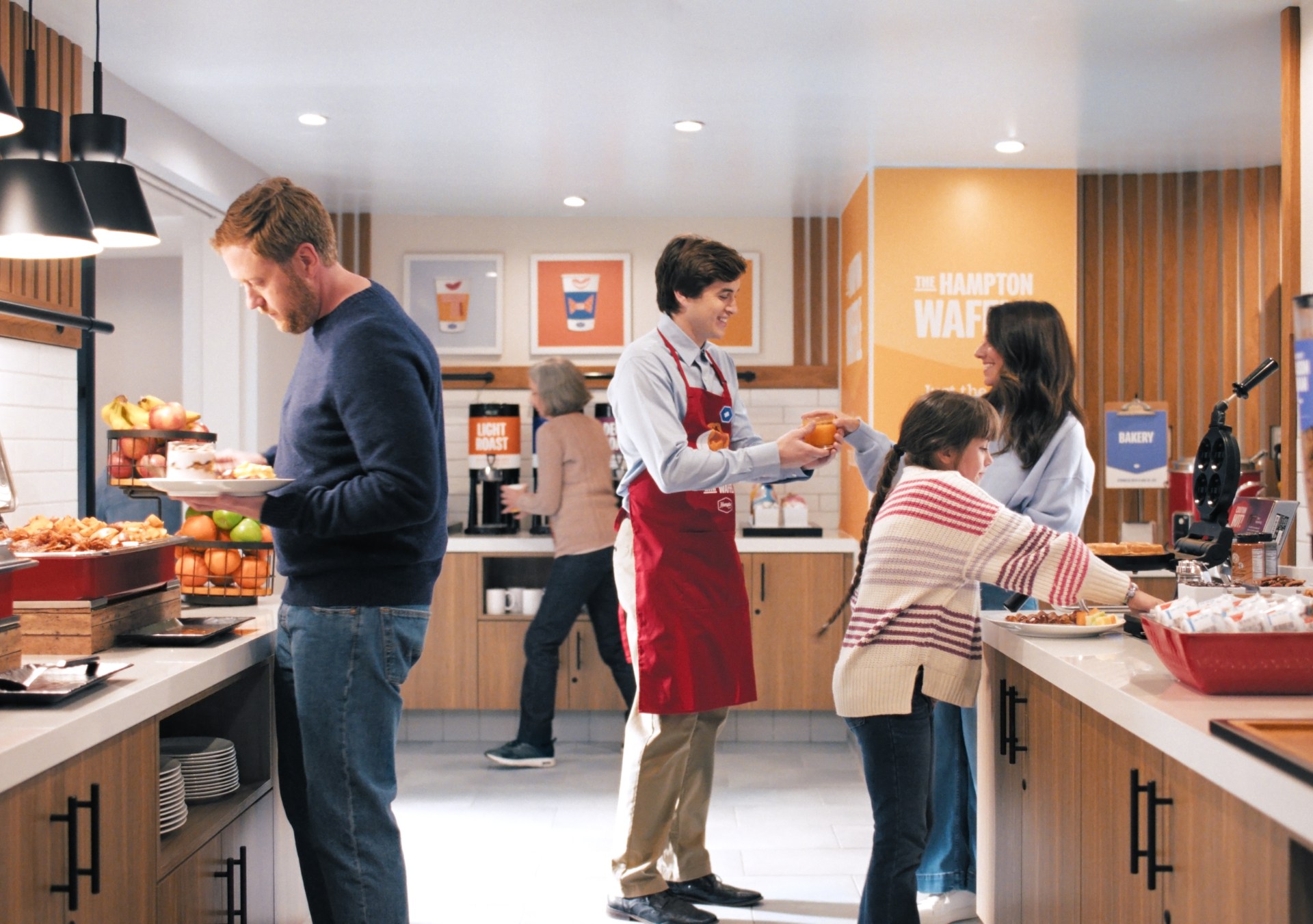 Guests and Hampton by Hilton Team members interacting at breakfast