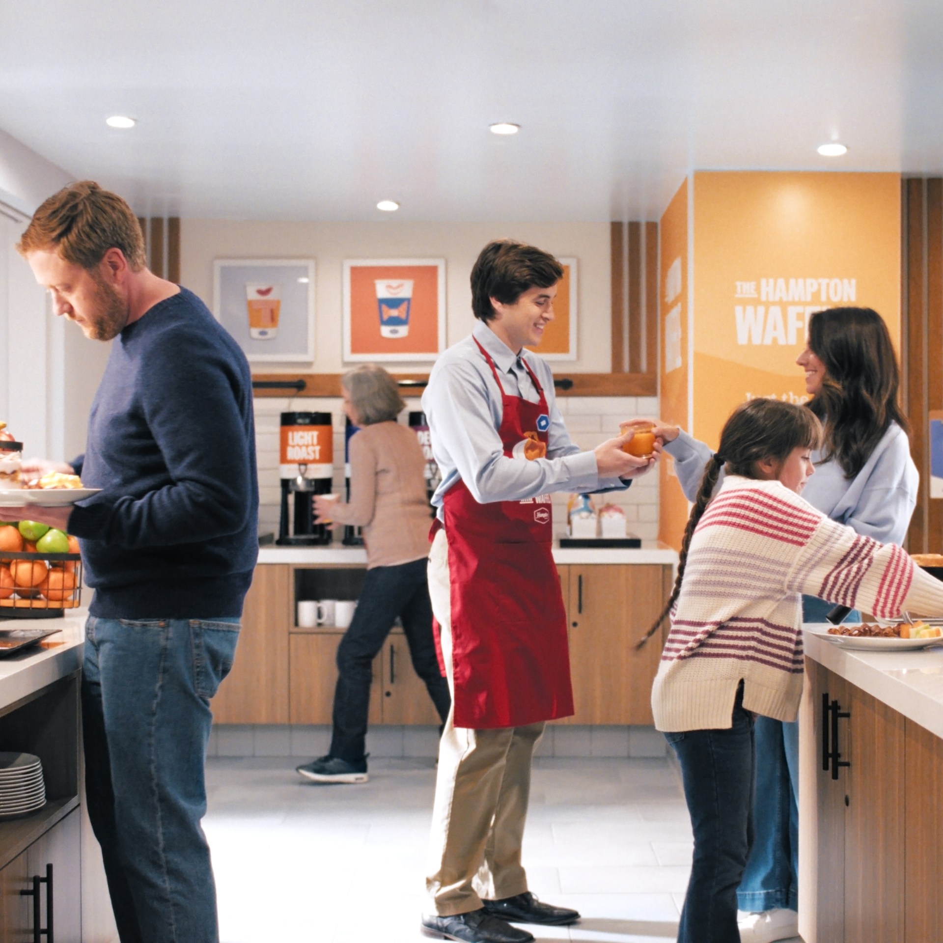 Guests and Hampton by Hilton Team members interacting at breakfast