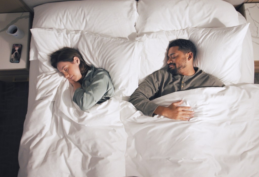 Guests relaxing in a bed at Hilton