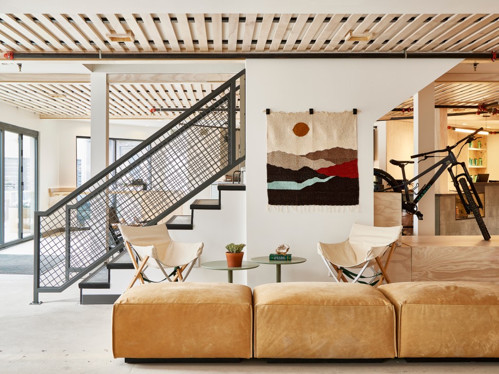 Slackline Moab, Outset Collection by Hilton - Lobby with leather seats, white walls, artwork with mountain scape, bicycle