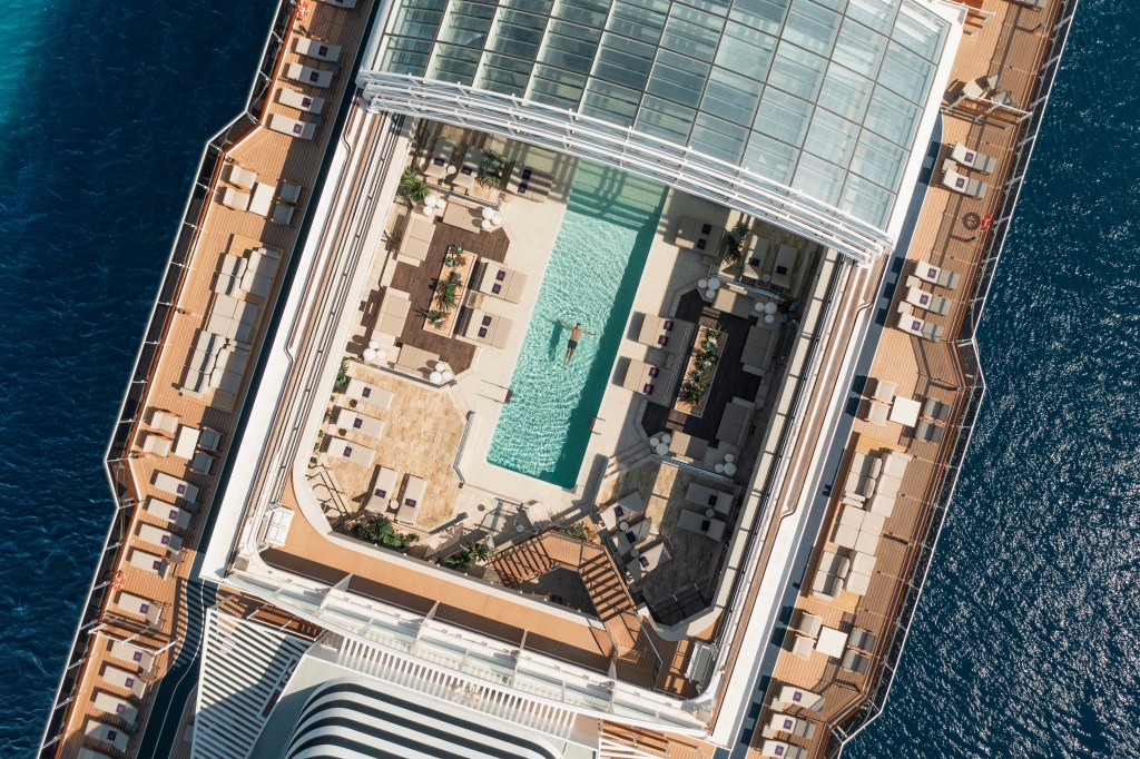Explora Journeys - Conservatory Pool View from above - man relaxing in pool