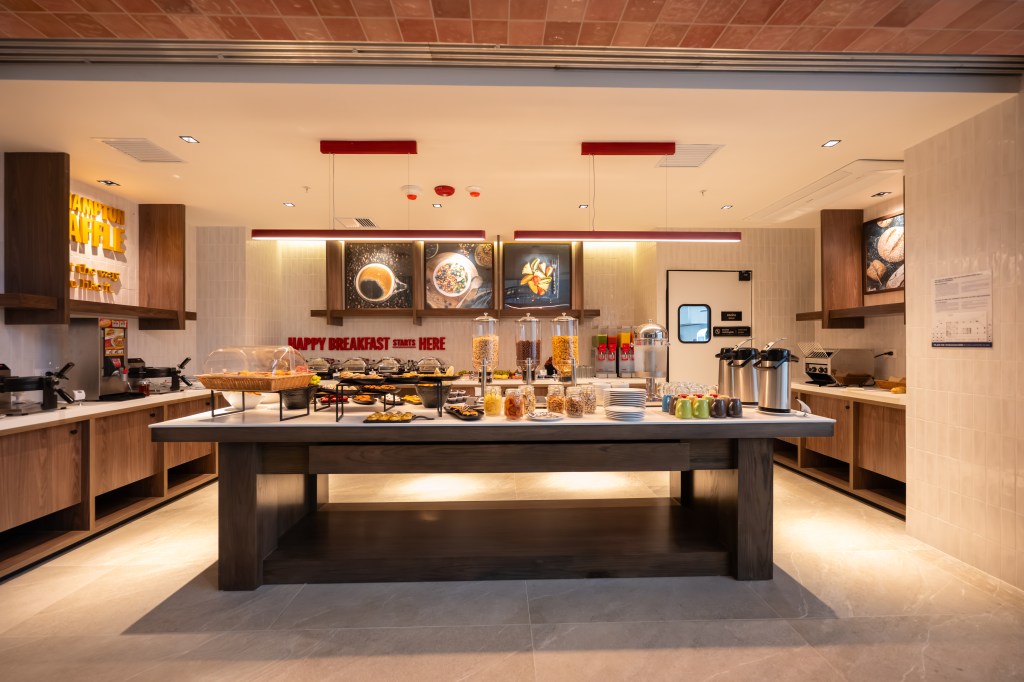 Hampton by Hilton Santiago de los Caballeros - breakfast area with white walls and wood accents, large center island with cereals, coffee, breakfast items