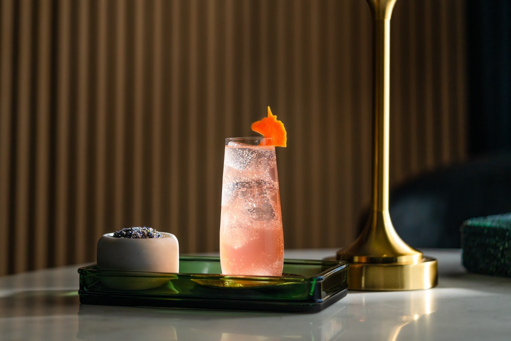 A sparkling pink drink on a tray