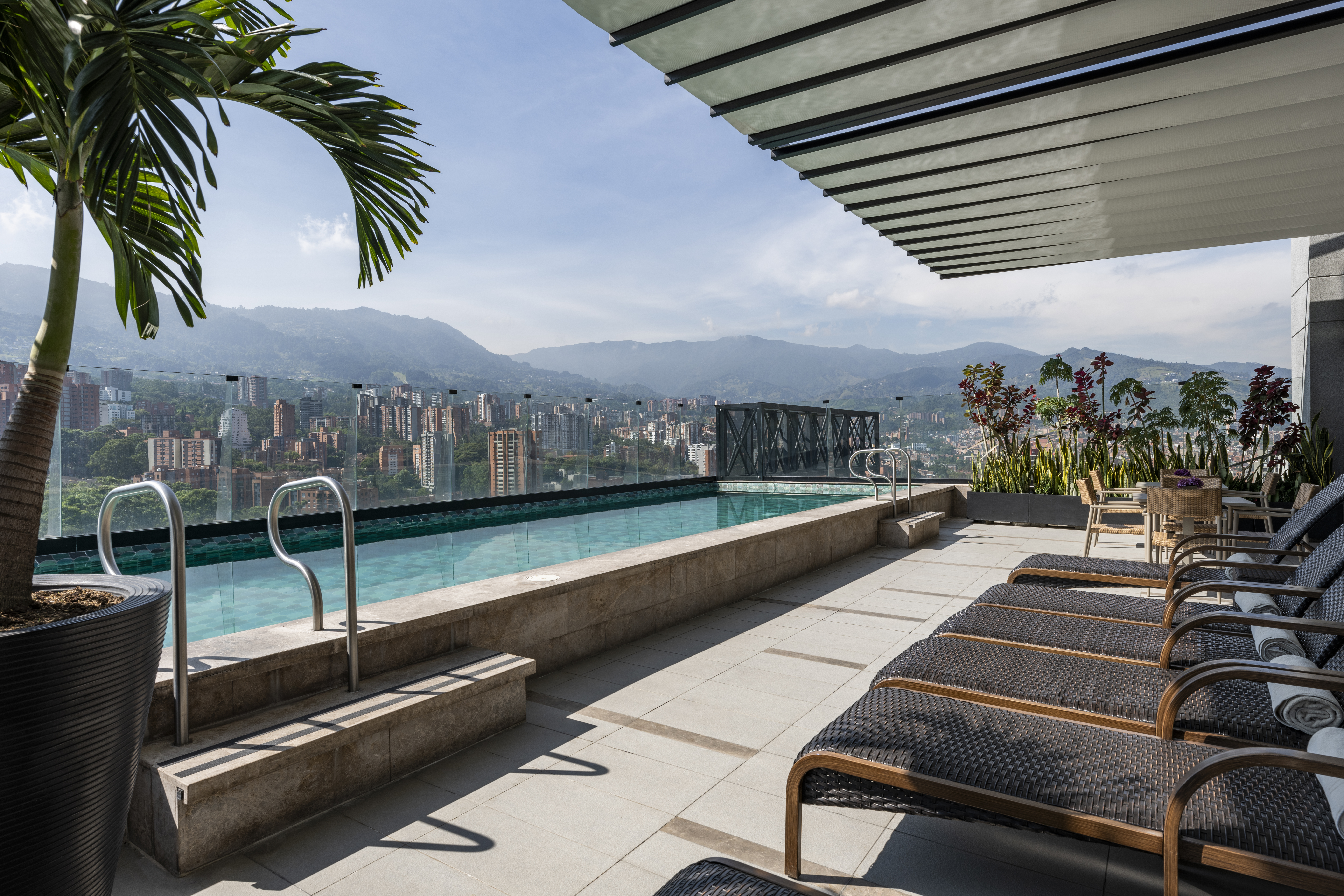 A rooftop pool overlooking the city, with lounge chairs beside