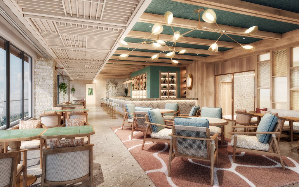 Stylish lounge with wood furniture, blue cushions, bar with backlit shelves, pendant lights, and large windows creating a bright, inviting space.