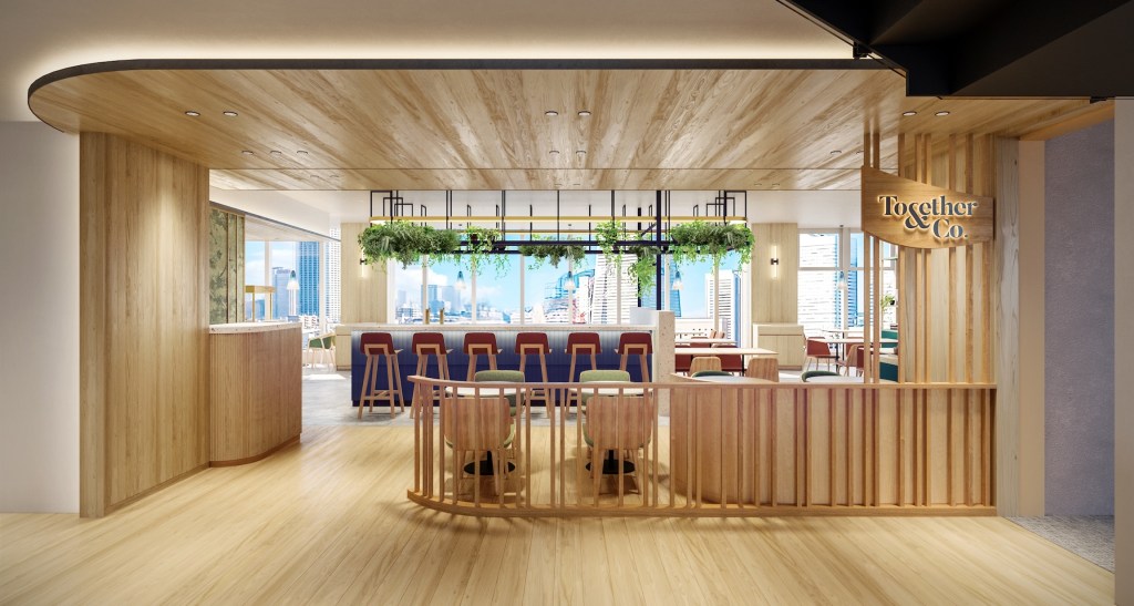 Modern office lounge with wood finishes, green-cushioned seating, bar with stools, hanging plants, city views, and “Together & Co.” signage.