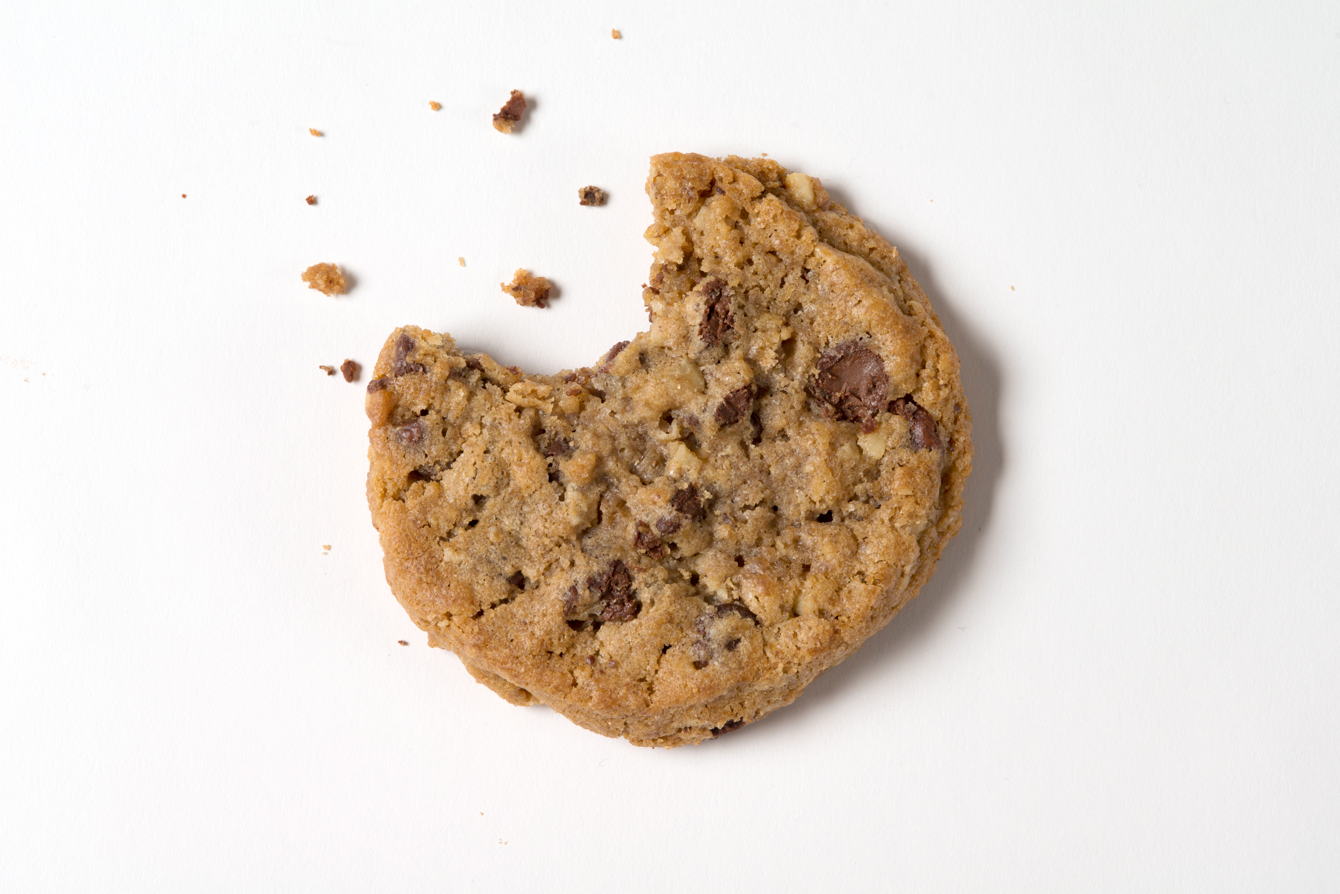 DoubleTree by Hilton chocolate chip cookie with a bite taken out, resting on a white surface.