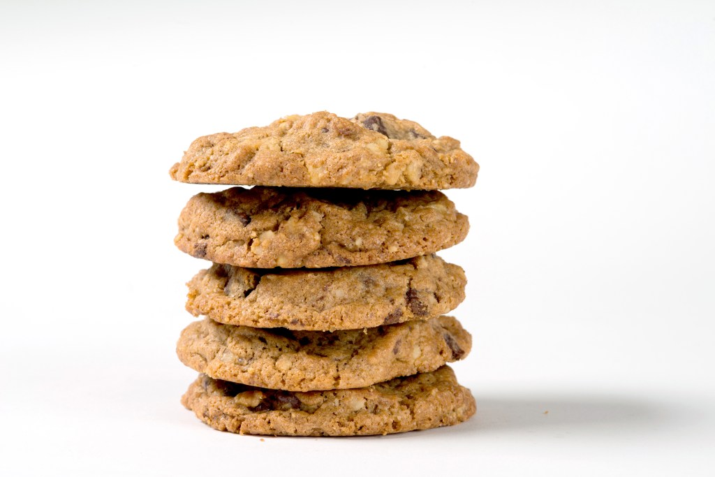 Stack of five DoubleTree by Hilton chocolate chip cookies on a white background.