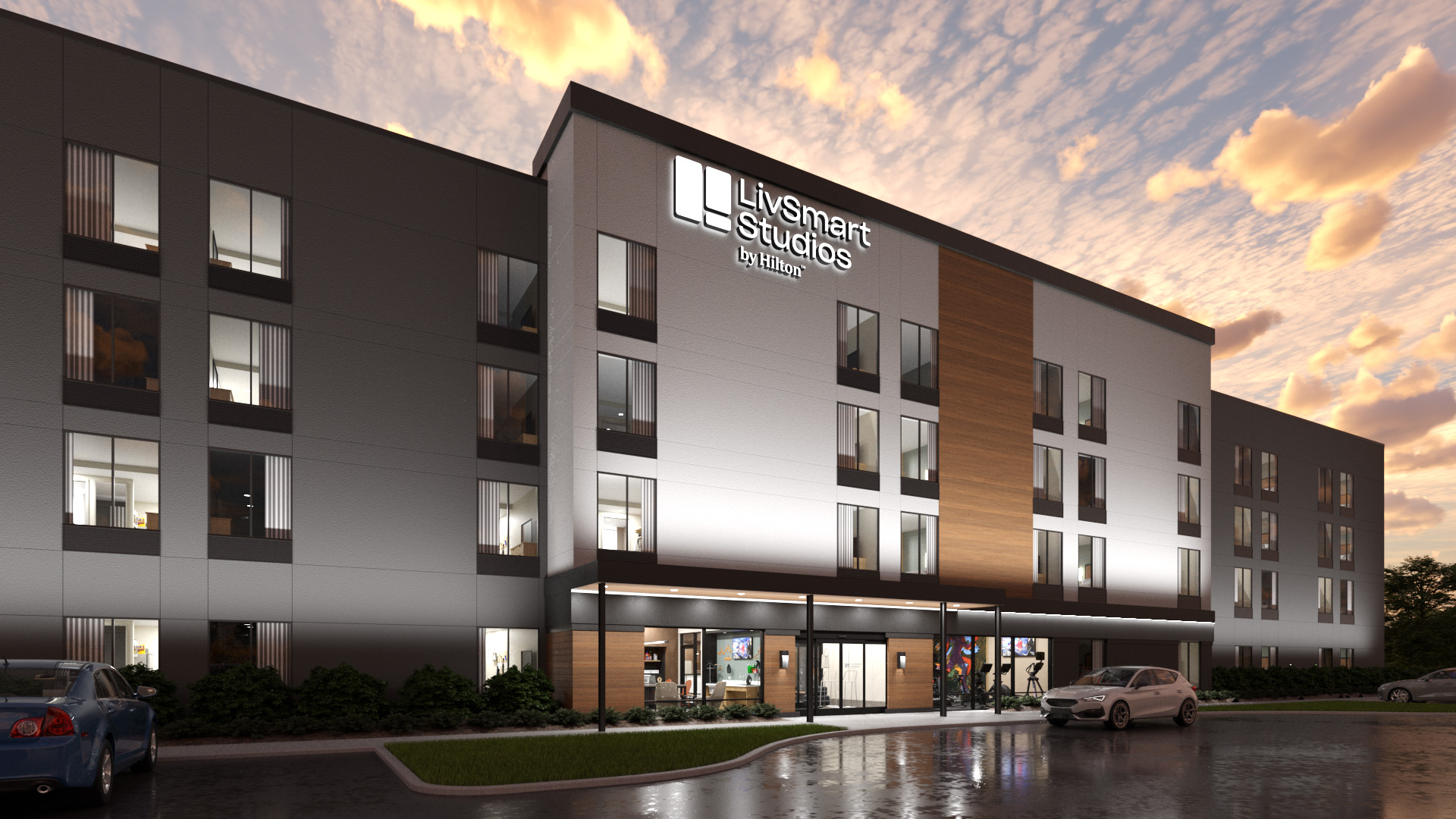 LivSmart Studios by Hilton building rendering at dusk with cars parked in front and a partly cloudy sky.
