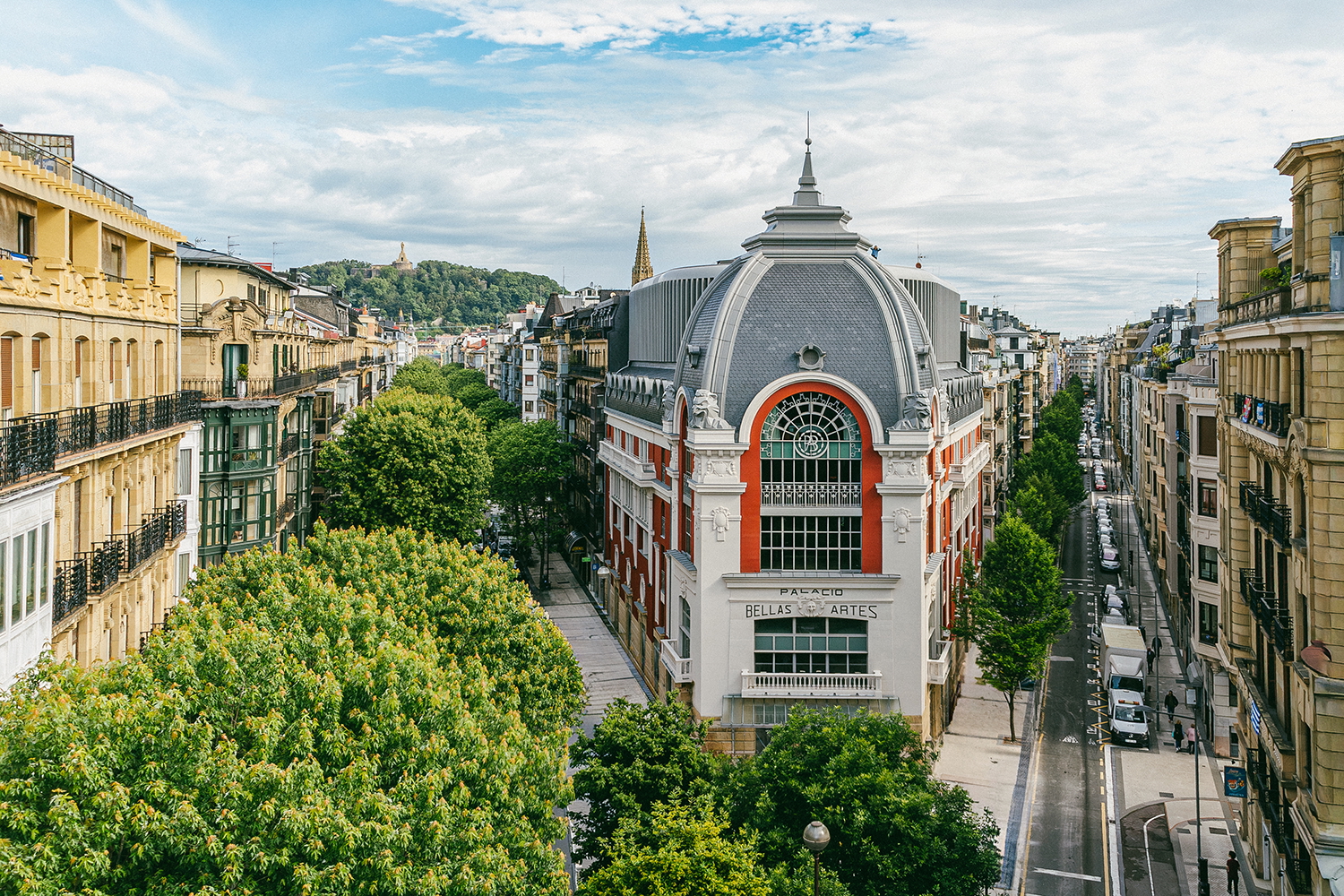 Palacio Bellas Artes, Curio Collection by Hilton exterior building with a gray dome and red accents, flanked by tree-lined streets.