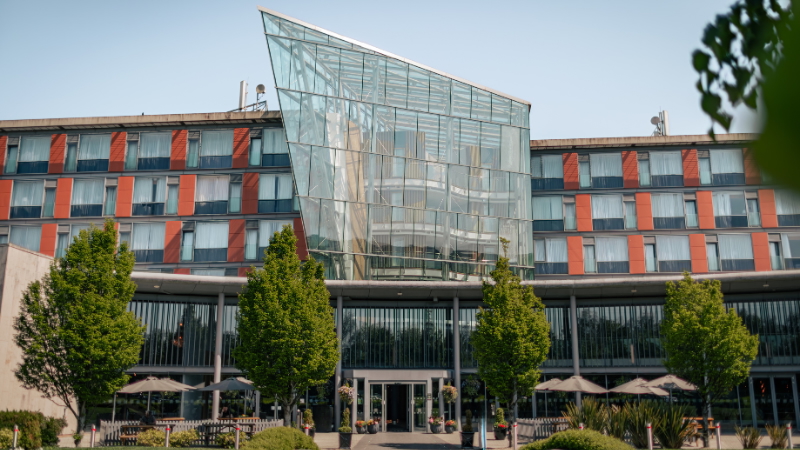Modern building of the DoubleTree by Hilton Ashbourne with large windows and a large glass box above the entrance.