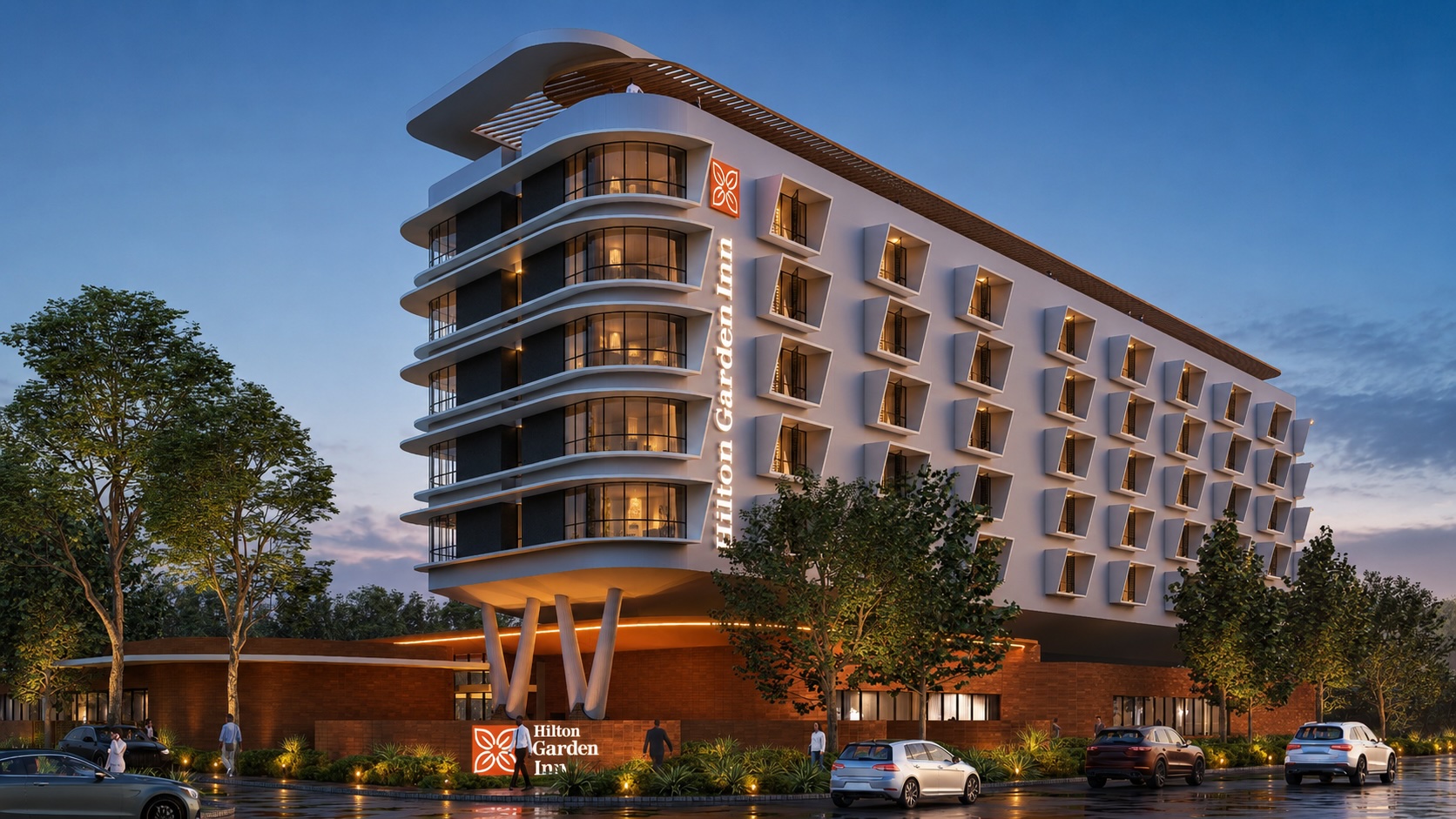 Modern Hilton Garden Inn Harare Highland building at dusk with illuminated windows, trees, and parked cars in front.